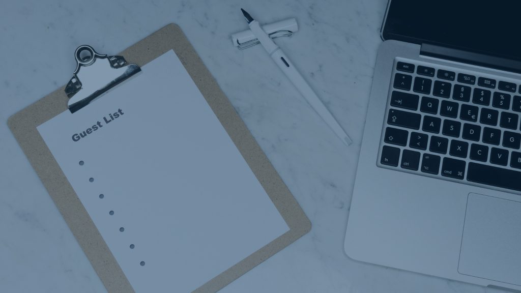 Overhead view of event planning setup: clipboard with 'Guest List' paper, white pen, and laptop on a desk; image has a blue color overlay.